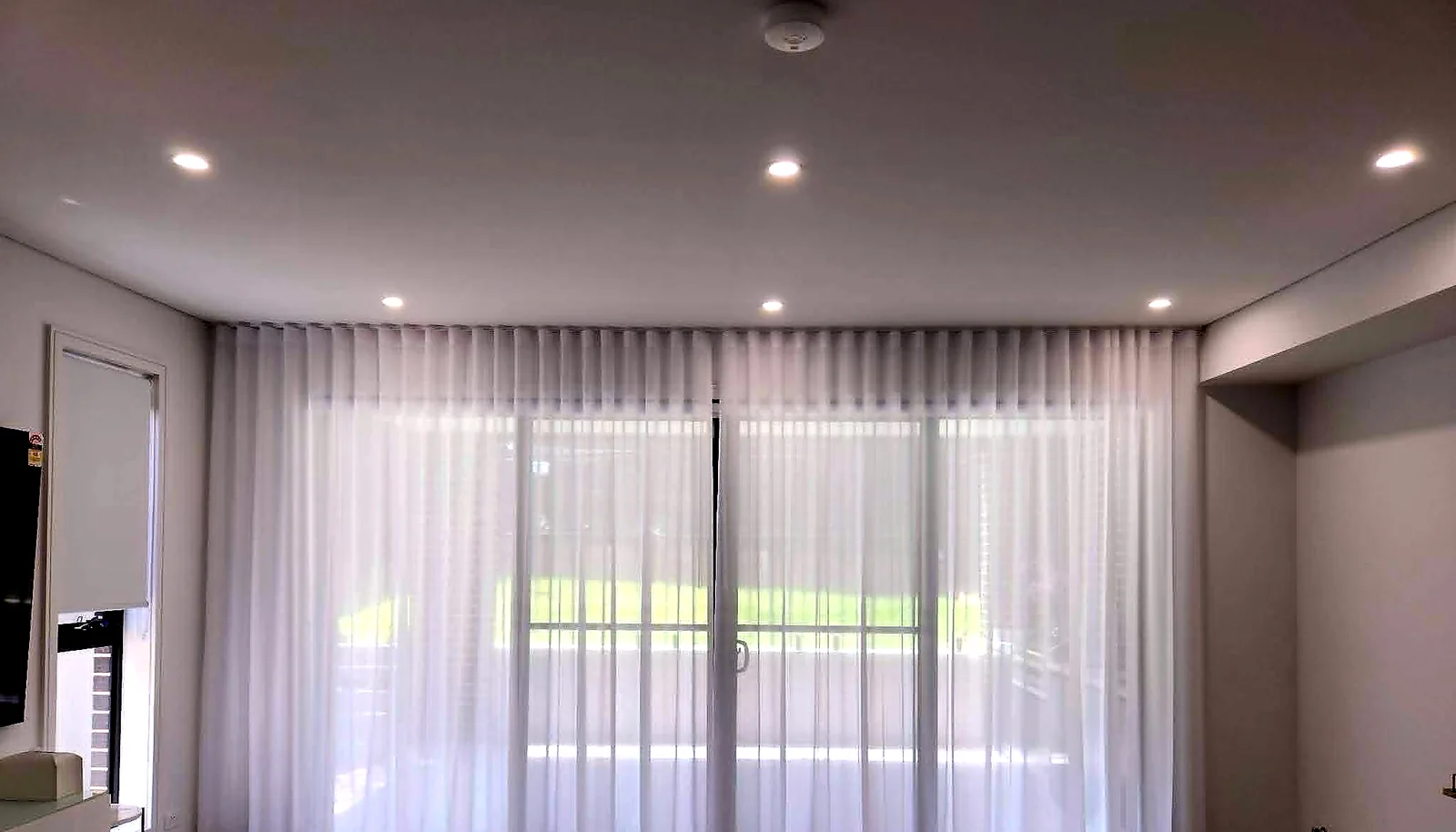 S-fold sheer curtains installed across a large living room sliding door in Brisbane